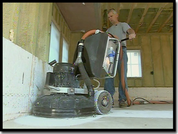 Concrete Renewal owner Greg Richard operating a heavy industrial diamond grinder to remove concrete surface laitance and ensure a permanent mechanical bond for a Poly-Quartz garage floor coating in the Twin Cities.